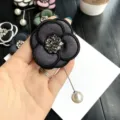 Primo piano dettaglio di spilla camelia vintage con strass scintillanti e spilla perla. - Grigio