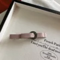 Vista dettagliata dell'elegante molletta per capelli in velluto rosa con strass sul vassoio. - Kaki