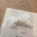 Primo piano del fermaglio per capelli con fiocco in tulle bianco, delicato organza stile. - bianco crema