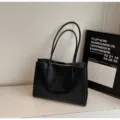 Detailed view of a minimalist black leather tote bag, perfect for daily commute and work use. - No Pendant / Black