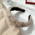 Gros plan d'un serre-tête beige tressé chic, accessoire de cheveux douillet d'hiver. - Blanc Cassé
