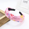 Cerchietto largo in tessuto rosa annodato con stampa alfabetica colorata per la moda quotidiana. - Rosa