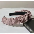 Close-up detail of a pink ruffled satin headband sparkling with crystal rhinestones. - Korean Pink