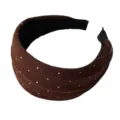 Detalle en primer plano de la diadema de punto marrón con lunares, textura suave y gran acabado. - Café