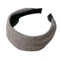 Primer plano de la diadema de punto gris con pequeños lunares blancos y forro interior negro. - Gris