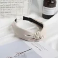 Vista detallada de diadema nudo de ante beige minimalista, accesorio de pelo de tela suave. - Blanco Roto