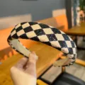 Detailed close-up of the black and white checkerboard wide headband showing textured PU leather. - Black