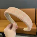 Gedetailleerd overzicht van een stijlvolle roze glinsterende kanten brede haarband top. - Oranje