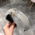 Cintillo de tela gris con borde dorado, primer plano detallado del diseño de diadema con nudo. - Gris