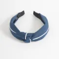 Primer plano detallado de la diadema de tela azul con ribete blanco y nudo. ¡Accesorio chic! - Azul marino