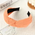 Orange knitted knotted headband for women, stylish wide fabric hair hoop daily accessory. - Orange