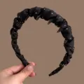 Black satin headband detail showcasing the pleated fabric design and anti-slip teeth features. - Black