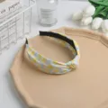Detalle de diadema de tela con estampado floral, flores amarillas y azules con nudo bonito. - Amarillo