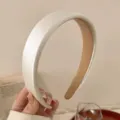 Primer plano detallado de una elegante diadema ancha blanca con textura suave y acabado fino. - Blanco Roto