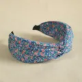Close-up view of blue floral knotted headband, wide fabric hair hoop for daily wear. - Lake Blue