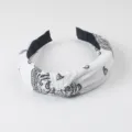 Vista detallada de la diadema anudada con estampado paisley en blanco y negro, elegante. - Blanco