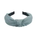 Primer plano detallado del elegante accesorio de diadema de tela gris azul con nudo. - Azul claro