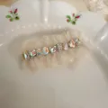 Close-up of sweet rhinestone lace hair clip featuring sparkling crystals and soft mesh ruffles. - Heart Rhinestone Duckbill Clip