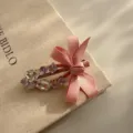 Detailed shot of sparkling rhinestone pink bow hair clip, sweet style side clip accessory. - Pink