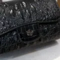 Detailed view of black crocodile pattern women shoulder bag with metal camellia clasp - Black