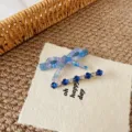 Vista dettagliata di fermagli per capelli blu con fiocco e strass floreali graziosi. - Set Fiocco Cristallo Blu Scuro