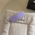 Dettaglio della forcina per capelli in tessuto a quadri viola con delicato fiore in metallo. - viola taro