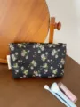 Floral cosmetic bag detail shot, featuring a black fabric with delicate flowers and zip closure. - M / Black Background Small Floral