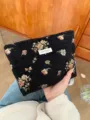 Detailed view of vintage black floral cosmetic bag with gold thread weave and convenient pouch design. - L / Black Gold Floral