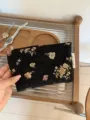 Close-up of vintage black brocade makeup pouch with gold floral weaving and side label detail. - M / Black Gold Floral