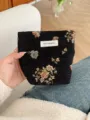 Detailed view of black vintage woven floral cosmetic bag with brand label detail showcase. - S / Black Gold Floral