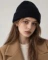 Detailed shot of a black wool-blend knitted beanie hat worn by model, cozy winter wear. - S (54-56cm) / Black