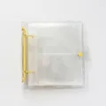 Vue détaillée du classeur de photocard transparent pailleté avec des anneaux jaunes et des poches. - Pince Jaune