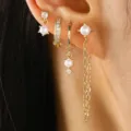 Close-up detail of multi-piece gold earrings set featuring pearls and sparkling cubic zirconia. - Gold (7350)