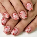 Close-up detail of short square glossy press-on nails with sweet pink and red heart art. - Pink Base Red and White Heart Style (YS014) / With Tool Kit