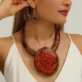 Close-up detail van opvallende chunky ketting en passende spiraal oorbellen set mode. - koffiekleur