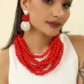 Gedetailleerde close-up van felrode gelaagde houten kraal statement ketting met oorbellen. - Rood