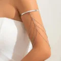 Dettaglio di polsino da braccio in argento con catene di strass multistrato e nappe. - Argento
