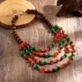 Gedetailleerde close-up van boho multi-layer ketting met houten en acryl kralen. - Kleurrijk