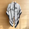 Detailed view of a square silk scarf featuring a classic chain and tassel print design with black border. - 130FJ55-Black