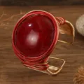 Detailopname van de grote rode hars edelsteen open manchet armband met geweven draad. - Rood