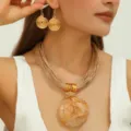 Close-up van trendy gouden spiraal oorbellen en multi-strand geweven koord ketting set. - Khaki