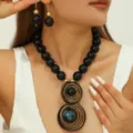 Chunky black bead necklace and matching earrings set with unique wire-wrapped pendant detail. - Black