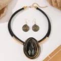 Zwart en goud statement sieradenset met geweven draad hangerketting en bijpassende oorbellen. - Zwart