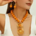 Chique oranje harskraal en gouden draad spiraal ketting oorbellen set voor dames. - Oranje