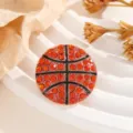 Close-up detail van een sprankelende rode strass basketbal broche mode accessoire. - Basketbal
