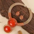 Close-up detail van opvallende ketting en oorbellen set met hars steen en draad wikkel. - Oranjerood