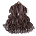 Detailed view of a lustrous brown scarf featuring exquisite white floral embroidery along edges. - Blue Mountain Coffee