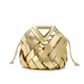 Gold woven leather handbag detail, featuring unique triangle handle and elegant tassel drawstring. - Gold