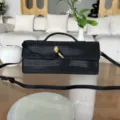 Sac de soirée noir en strass avec fermoir serpent doré, poignée métallique et bandoulière chic. - Noir