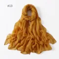 Detail view of the lightweight solid color polyester long scarf in mustard yellow, soft texture. - 13